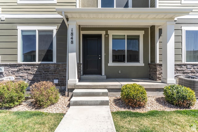 view of exterior entry featuring a porch and stone siding