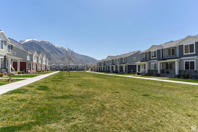 view of home's community with a residential view, a lawn, and a mountain view