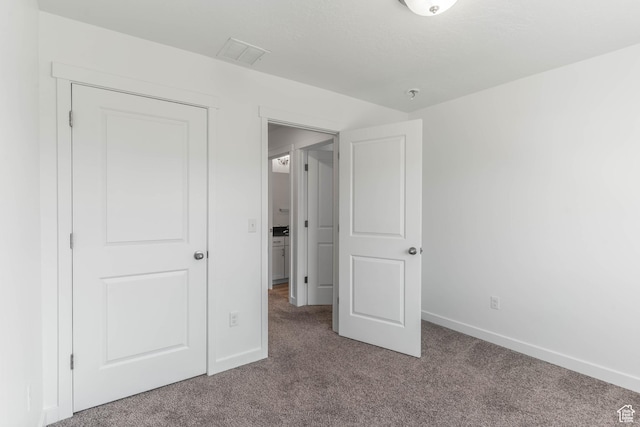 unfurnished bedroom featuring visible vents, baseboards, and carpet