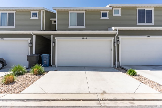 townhome / multi-family property with an attached garage and concrete driveway
