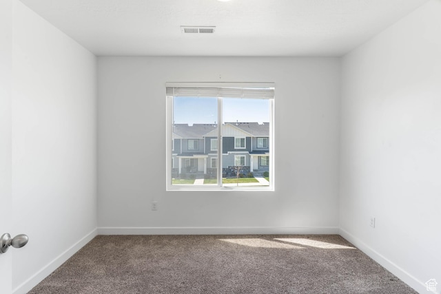spare room with baseboards, carpet flooring, and visible vents