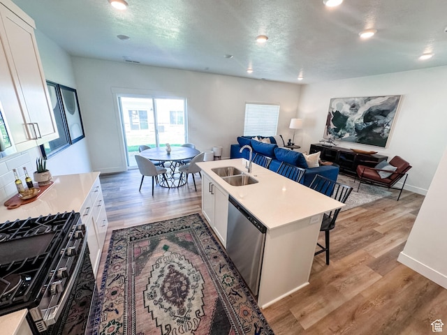 627 W 575 N Unit 545, Smithfield, UT 84335 - kitchen with stainless steel dishwasher, a kitchen breakfast bar, a sink, white cabinetry, and range with gas stovetop