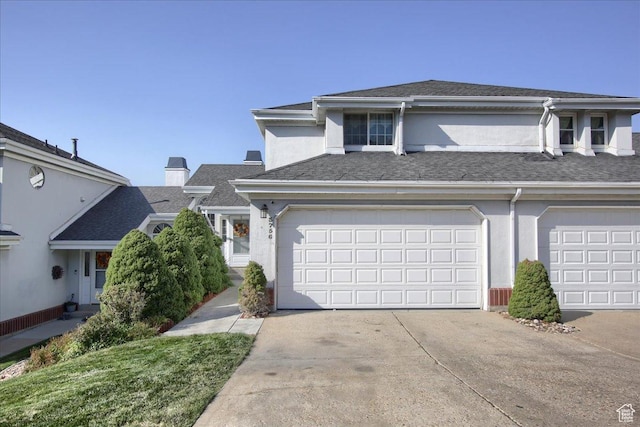 view of property with a shingled roof, driveway, and stucco siding
