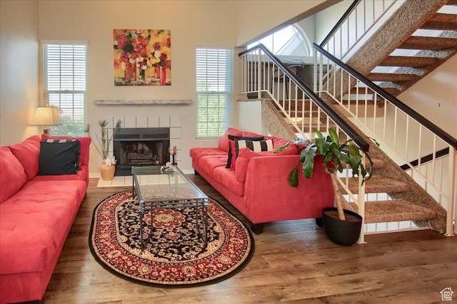 living room with stairs, a healthy amount of sunlight, and wood finished floors