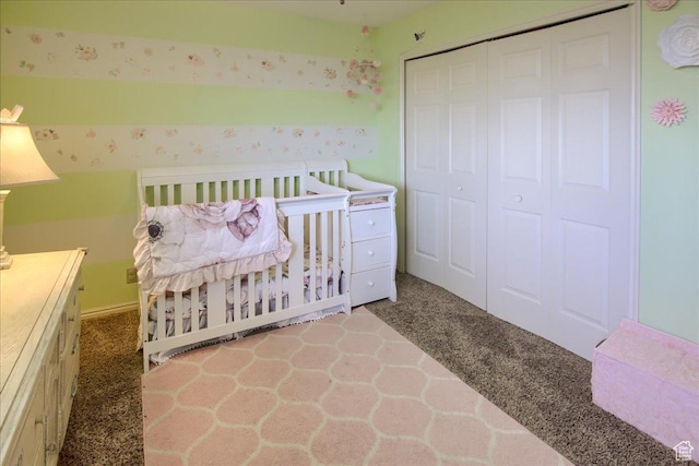 carpeted bedroom with wallpapered walls and a closet