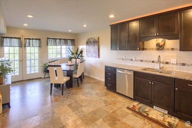 kitchen with tasteful backsplash, dishwasher, dark brown cabinetry, and a sink