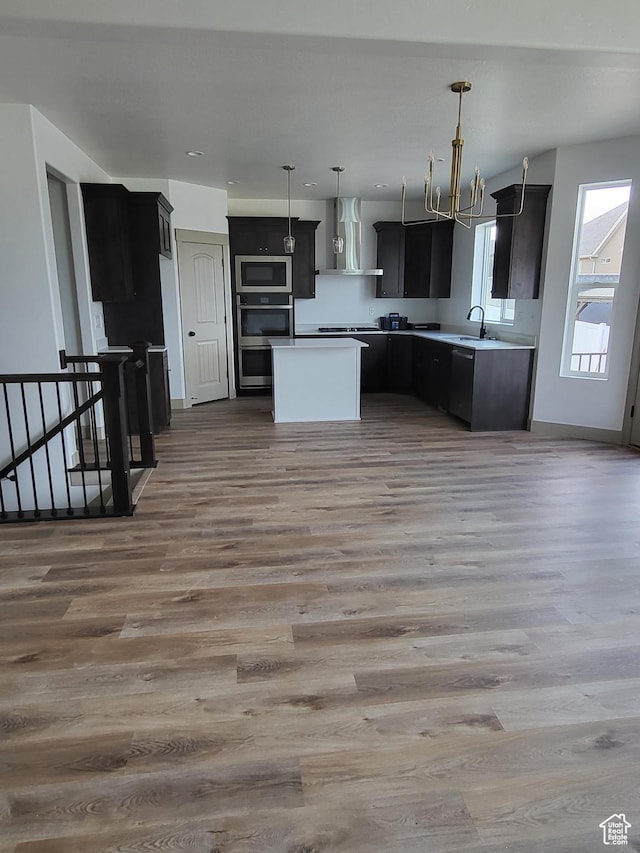 5682 W 7220 S, West Jordan, UT 84081 - kitchen with stainless steel microwave, wall chimney exhaust hood, a kitchen island, and light wood-type flooring