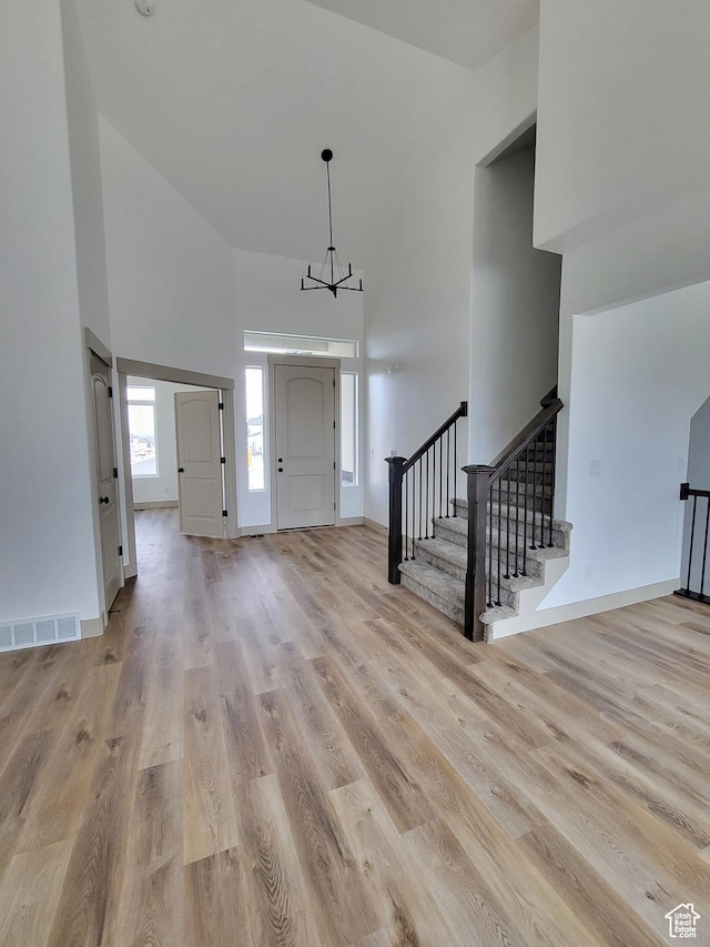 5682 W 7220 S, West Jordan, UT 84081 - foyer entrance featuring light wood finished floors, a towering ceiling, an inviting chandelier, visible vents, and stairs