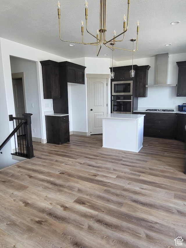 5682 W 7220 S, West Jordan, UT 84081 - kitchen with wall chimney range hood, stainless steel appliances, light wood-style flooring, a kitchen island, and recessed lighting