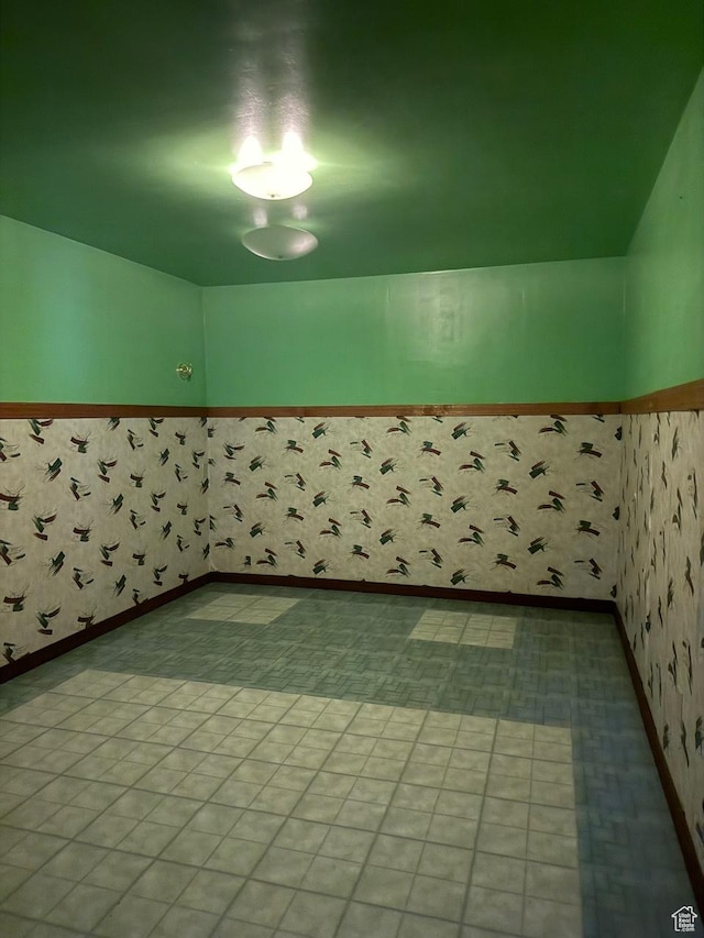 spare room with wainscoting and wallpapered walls