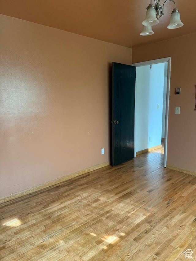 unfurnished room with baseboards and light wood-style flooring