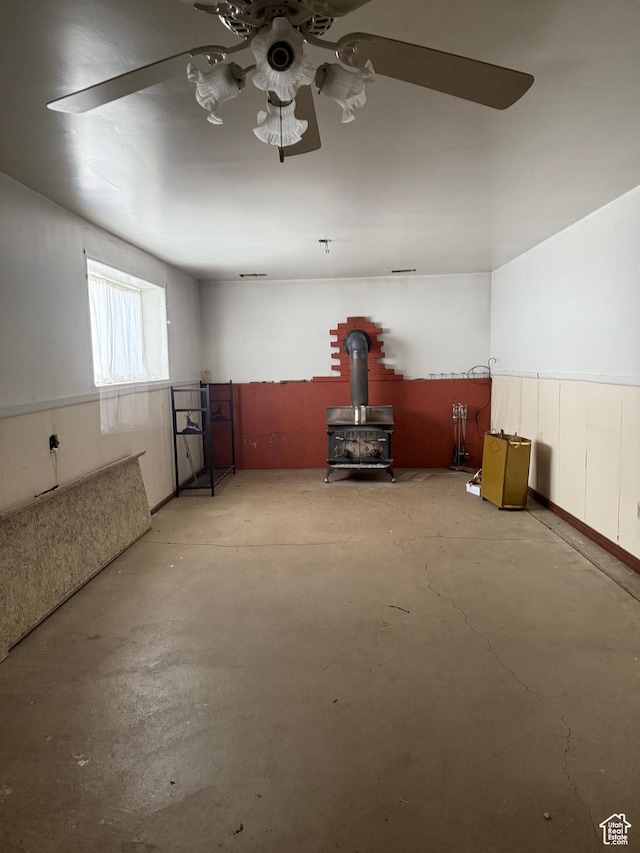 interior space featuring a ceiling fan and a wood stove