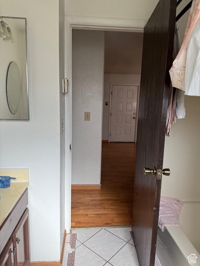 hall featuring baseboards and light tile patterned floors