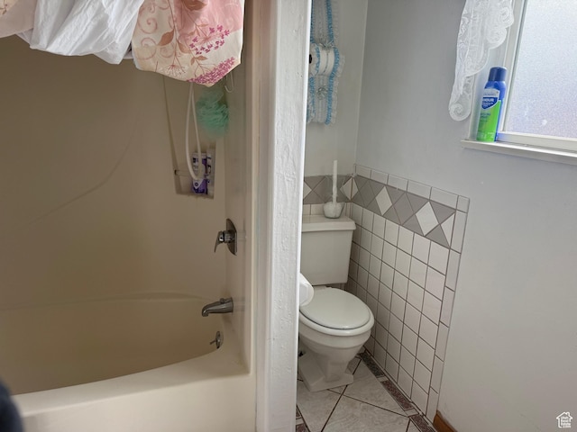 bathroom featuring tile walls, tile patterned flooring, shower / tub combination, and toilet