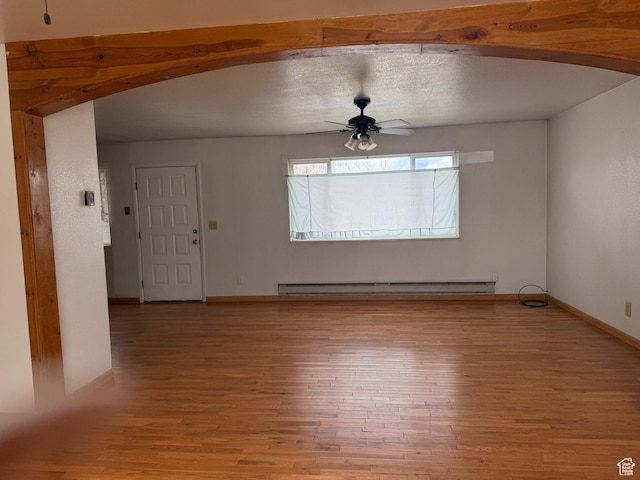 unfurnished living room featuring light wood-style floors, baseboards, baseboard heating, and ceiling fan