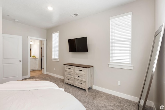 bedroom featuring light colored carpet, baseboards, and visible vents