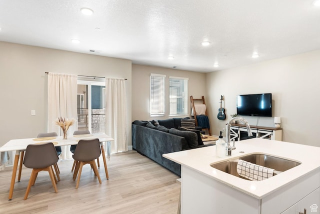 living room featuring recessed lighting, visible vents, and light wood-style flooring