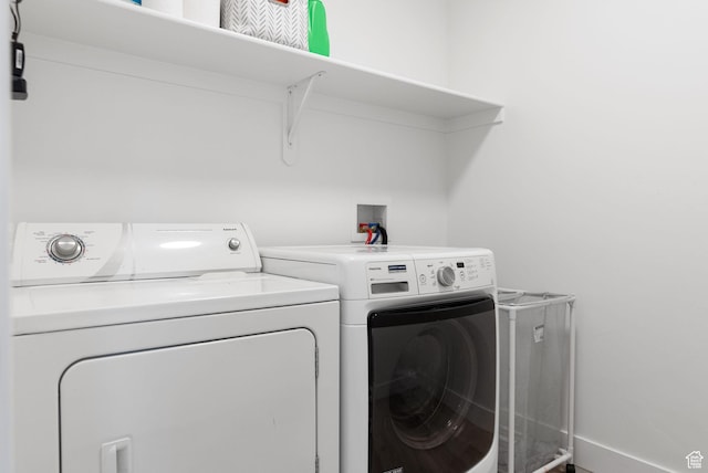 laundry room featuring washing machine and clothes dryer, baseboards, and laundry area
