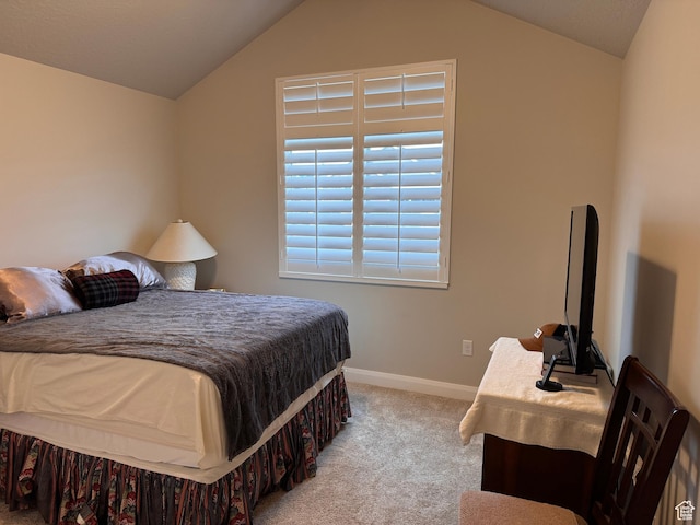 carpeted bedroom with lofted ceiling and baseboards