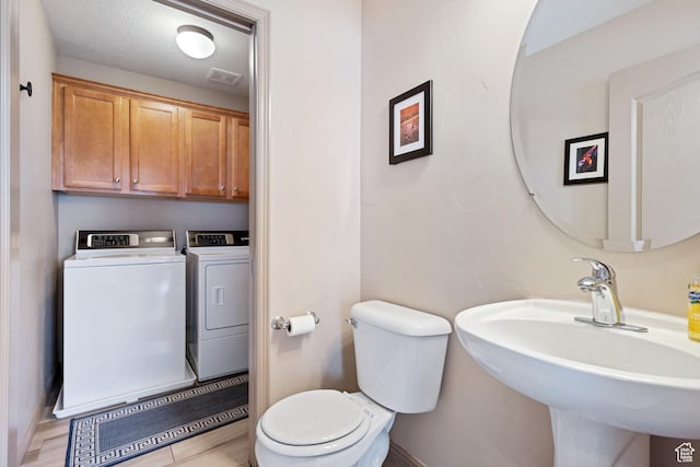 5701 W Emmeline Dr, Herriman, UT 84096 - bathroom with a sink, toilet, baseboards, visible vents, and separate washer and dryer