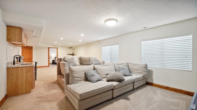living room with wet bar, visible vents, baseboards, and light carpet