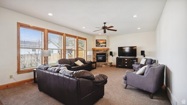 living area featuring baseboards, carpet, recessed lighting, ceiling fan, and a stone fireplace