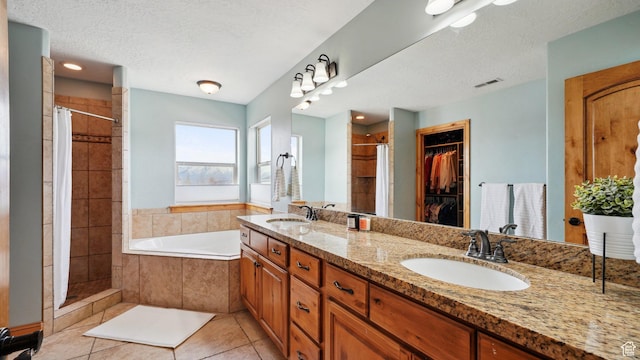 full bathroom with tile patterned flooring, a stall shower, and a sink