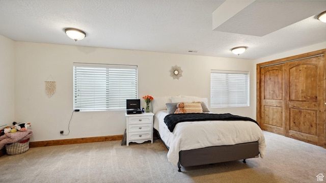 carpeted bedroom with a closet, visible vents, baseboards, and multiple windows