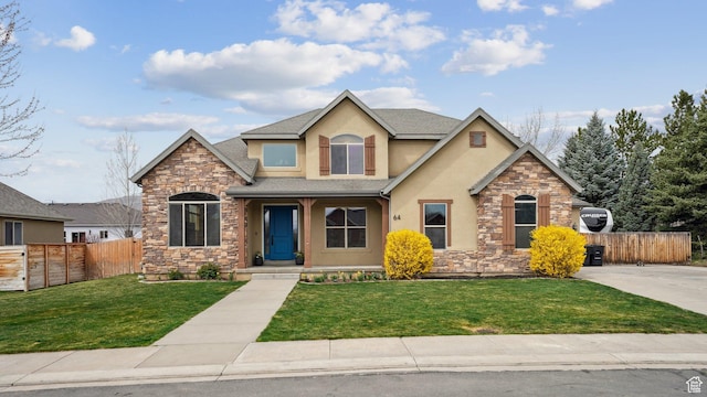 craftsman house with stone siding, a front yard, stucco siding, and fence