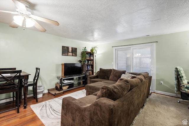 living room with ceiling fan, baseboards, wood finished floors, and a textured ceiling