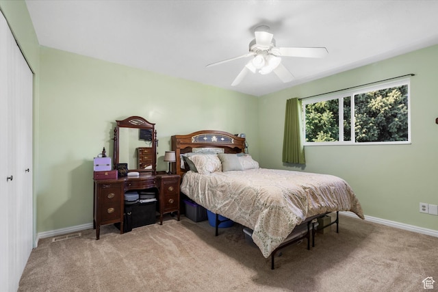 carpeted bedroom with a closet, a ceiling fan, baseboards, and visible vents
