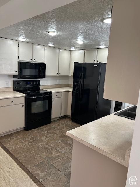 2590 W Central Pk Cir, Taylorsville, UT 84129 - kitchen with black appliances, light countertops, white cabinets, and dark stone finish flooring