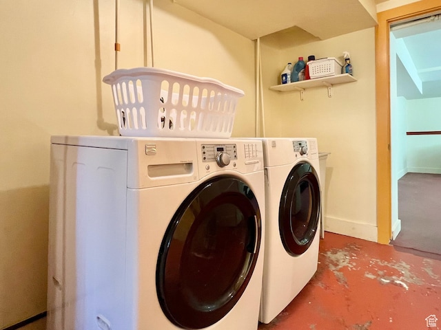 laundry area featuring washing machine and clothes dryer, baseboards, and laundry area