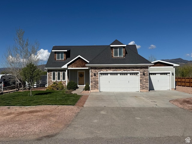 craftsman-style house with fence, an attached garage, stone siding, a front yard, and concrete driveway