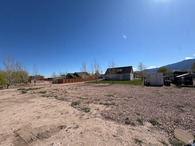 view of yard featuring fence and a mountain view