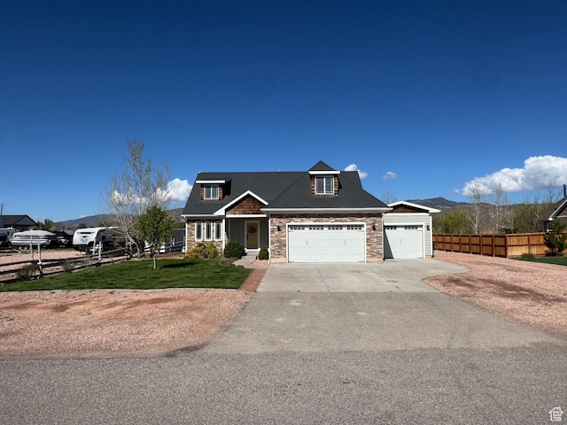 craftsman inspired home with fence, an attached garage, concrete driveway, and a front lawn