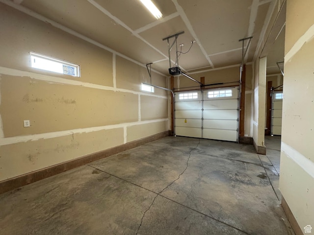 garage with baseboards and a garage door opener