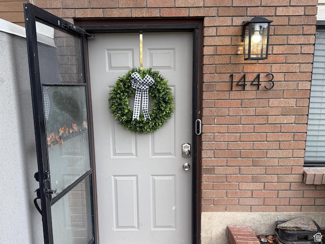 view of exterior entry with brick siding