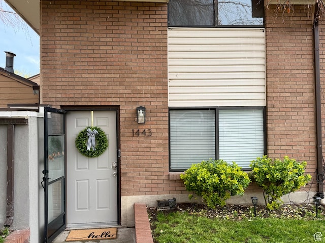 property entrance featuring brick siding