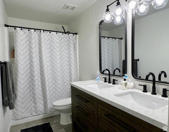 full bath with visible vents, a sink, double vanity, and toilet