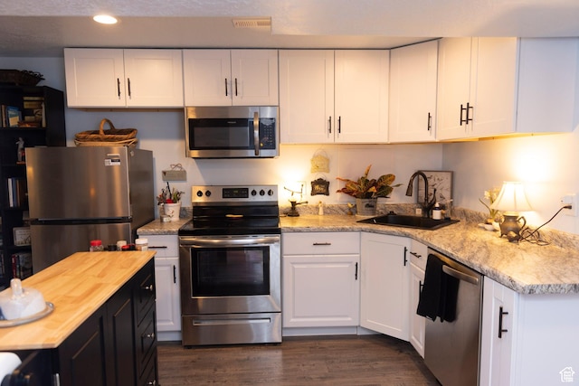 7532 N Castle Rock Rd E, Eagle Mountain, UT 84005 - kitchen featuring stainless steel appliances, a sink, butcher block countertops, and white cabinetry