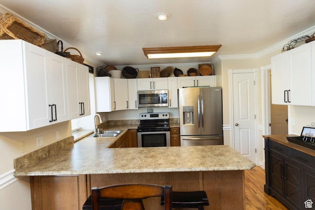 7532 N Castle Rock Rd E, Eagle Mountain, UT 84005 - kitchen featuring stainless steel appliances, a peninsula, a kitchen breakfast bar, a sink, and ornamental molding