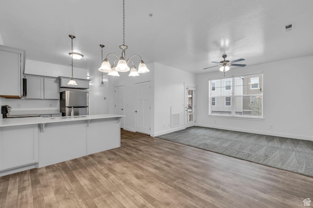 84 W Silver Springs Dr, Vineyard, UT 84059 - kitchen featuring a peninsula, freestanding refrigerator, ceiling fan with notable chandelier, electric range oven, and light countertops