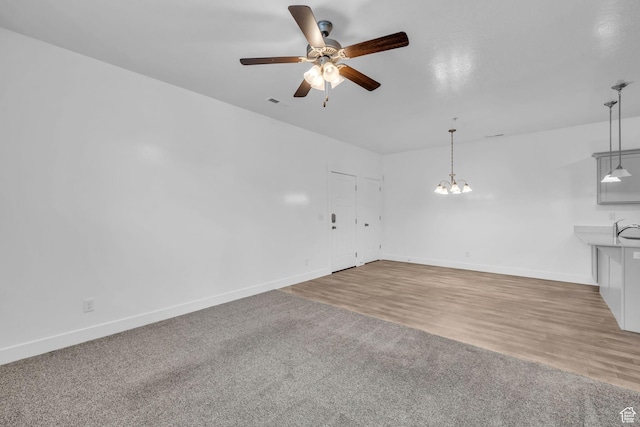 84 W Silver Springs Dr, Vineyard, UT 84059 - unfurnished living room with ceiling fan with notable chandelier, baseboards, a sink, and visible vents