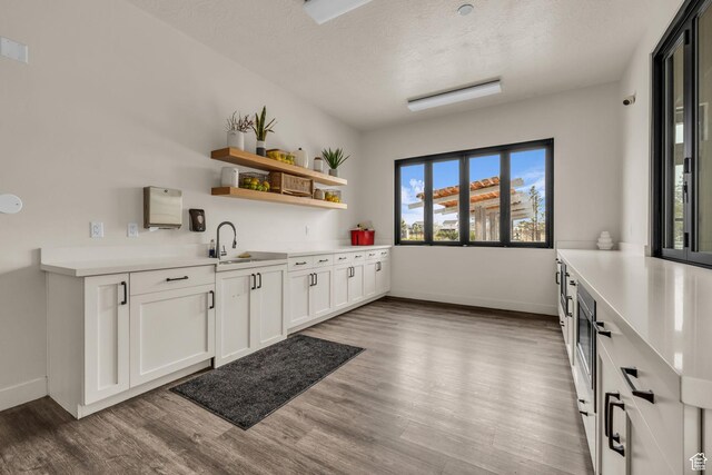 84 W Silver Springs Dr, Vineyard, UT 84059 - kitchen featuring light countertops, wood finished floors, baseboards, and a sink
