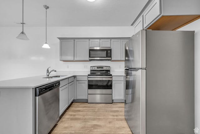 84 W Silver Springs Dr, Vineyard, UT 84059 - kitchen featuring a peninsula, light wood-style flooring, a sink, gray cabinets, and appliances with stainless steel finishes