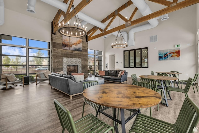 84 W Silver Springs Dr, Vineyard, UT 84059 - dining room with visible vents, a chandelier, wood finished floors, a fireplace, and high vaulted ceiling