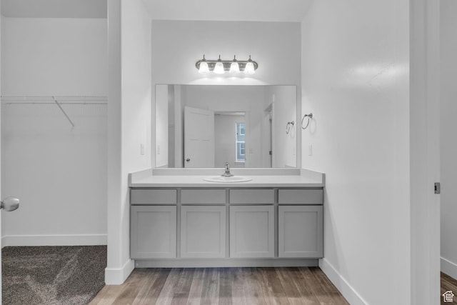 84 W Silver Springs Dr, Vineyard, UT 84059 - bathroom featuring a spacious closet, wood finished floors, vanity, and baseboards