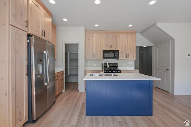 kitchen with light countertops, light brown cabinets, a sink, and black appliances