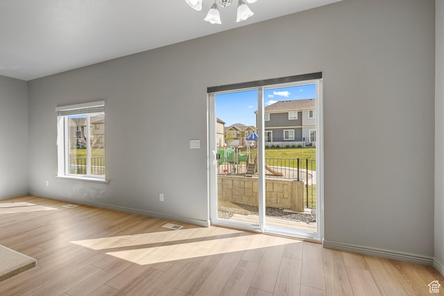 doorway to outside featuring visible vents, baseboards, and wood finished floors